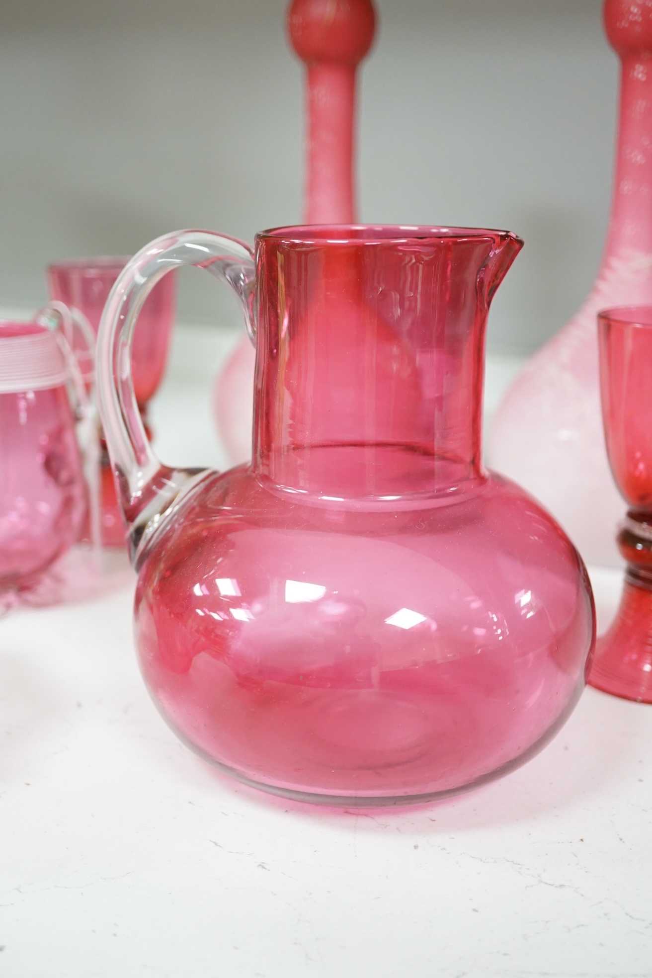 A pair of Victorian pink satin long necked vases, 25cm high, and five pieces of cranberry coloured glassware, (8). Condition - fair to good.